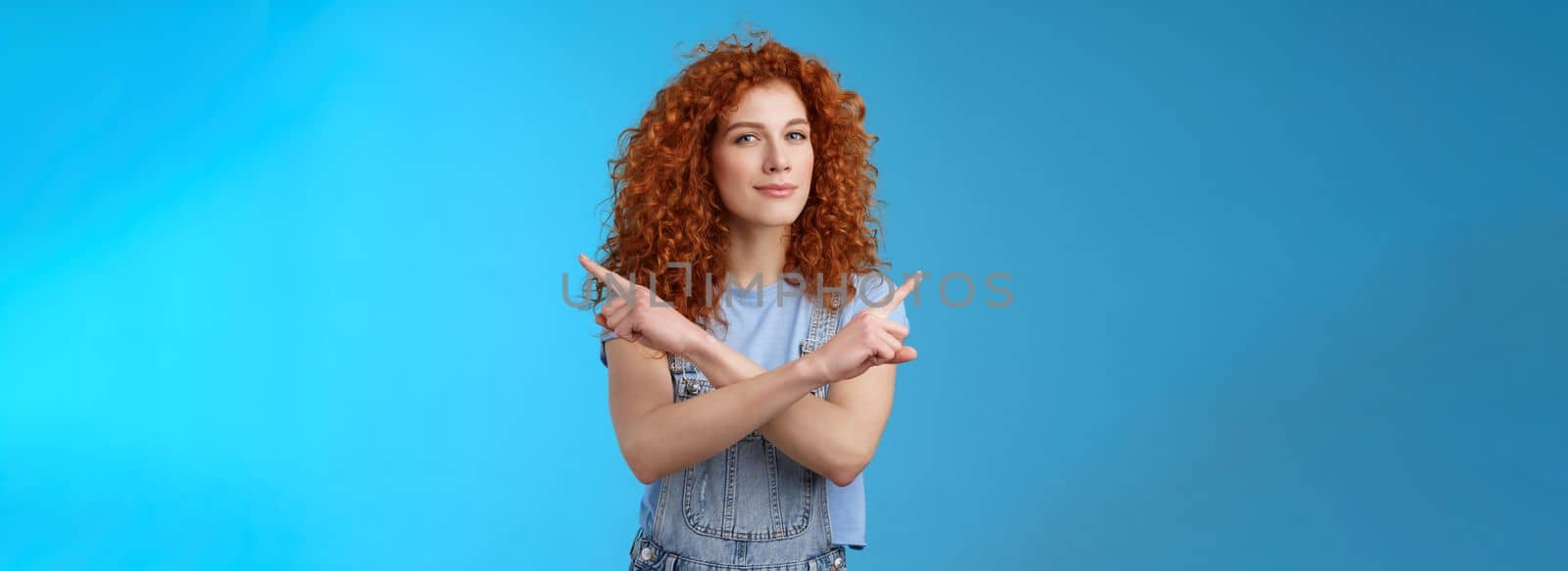 Lifestyle. Curious creative redhead attractive modern young curly-haired female look intrigued pointing sideways left right squinting camera asking advice making choice deciding which product blue background.