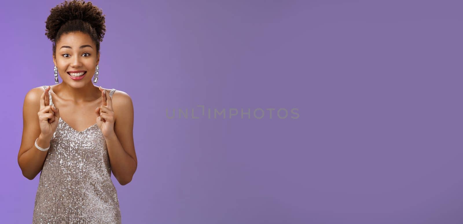Excited lucky hopeful charming african american female model hopes win competition cross fingers dreamy smiling optimistic believe fortune praying dream come true, make wish blue background by Benzoix