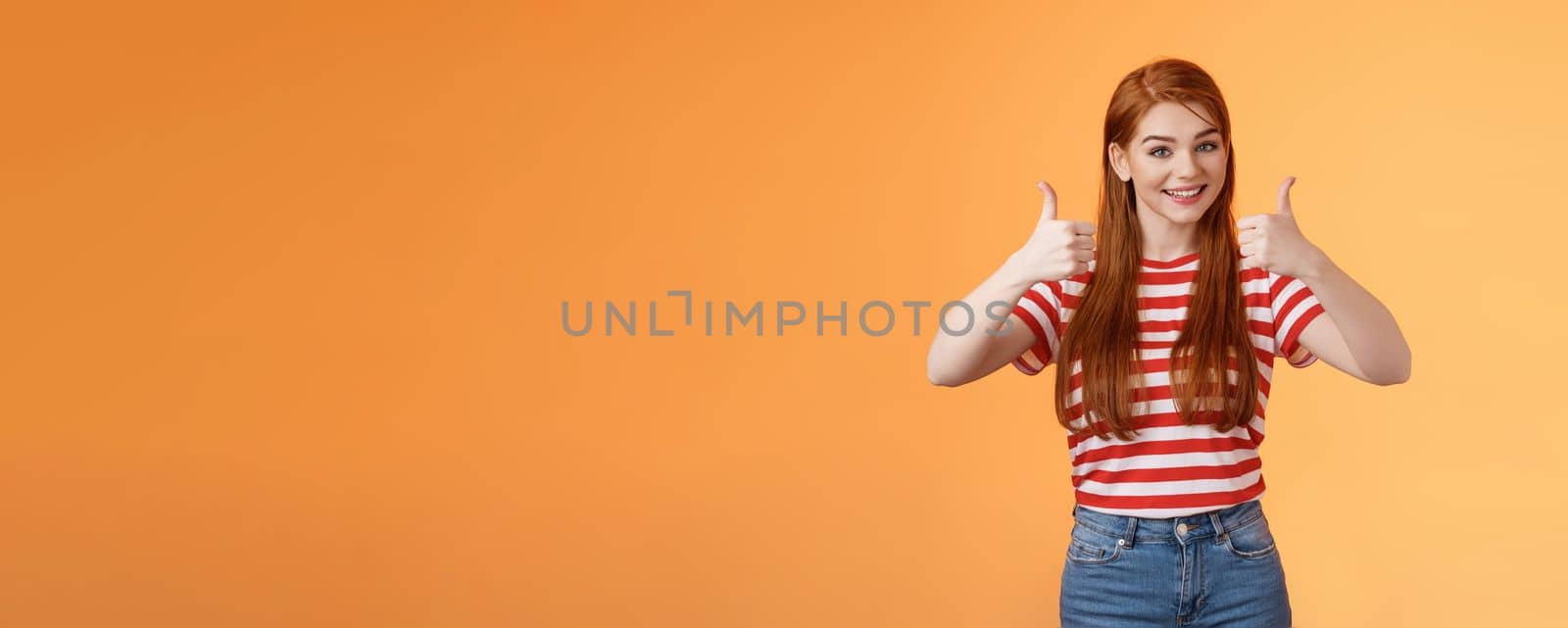 Good work, keep going. Girl encourage friend, say well done, show satisfactory sign, thumbs-up and smiling pleased, agree, approve nice choice, accept point view, stand orange background.