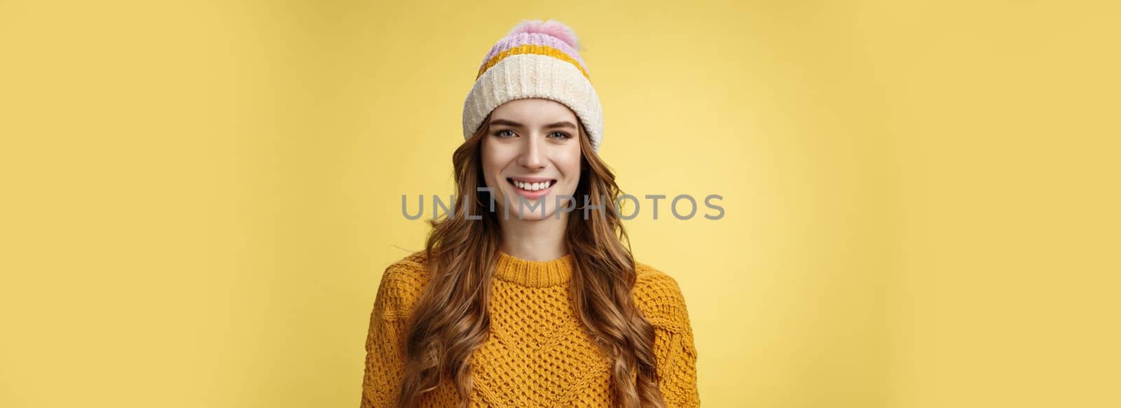 Attractive young friendly-looking outgoing girl dressed warm travel mountains skiing having fun spend winter holidays alps family, smiling broadly wearing corduroy hat sweater, yellow background.