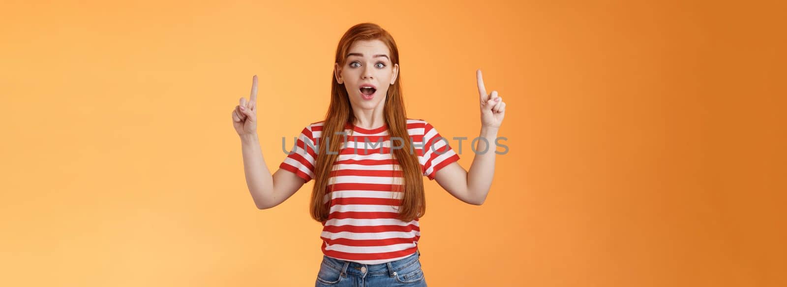 Surprised cute girl 20s long red hair lovely ears, inspired awesome interesting lecture showing you copy space up promo, open mouth amused, fascinated stare camera, explain news by Benzoix