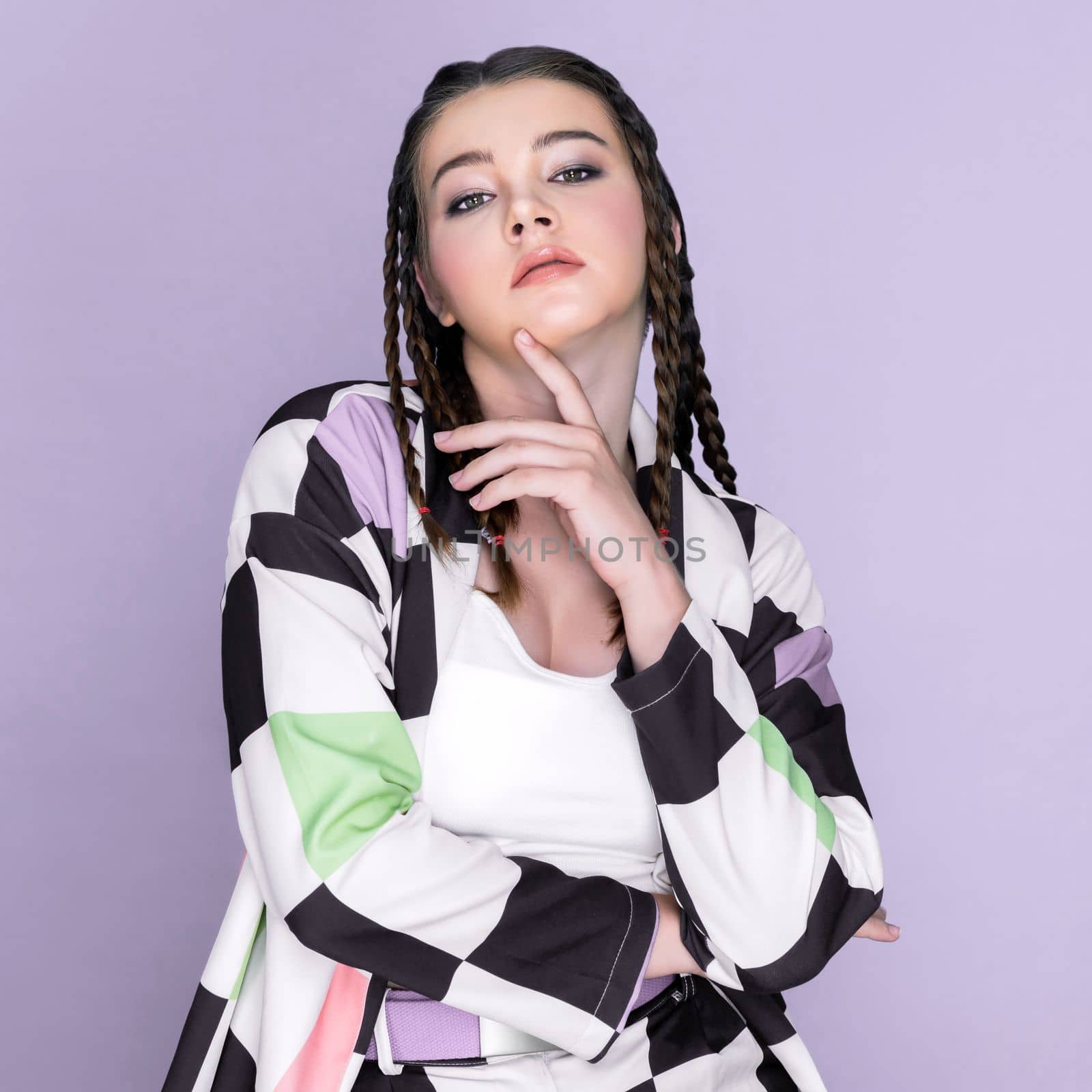 Closeup beautiful young girl with perfect skin, cosmetic and long braid posing with trendy fashion outfit in the studio with isolated background. charming young teenage with beauty gesture.