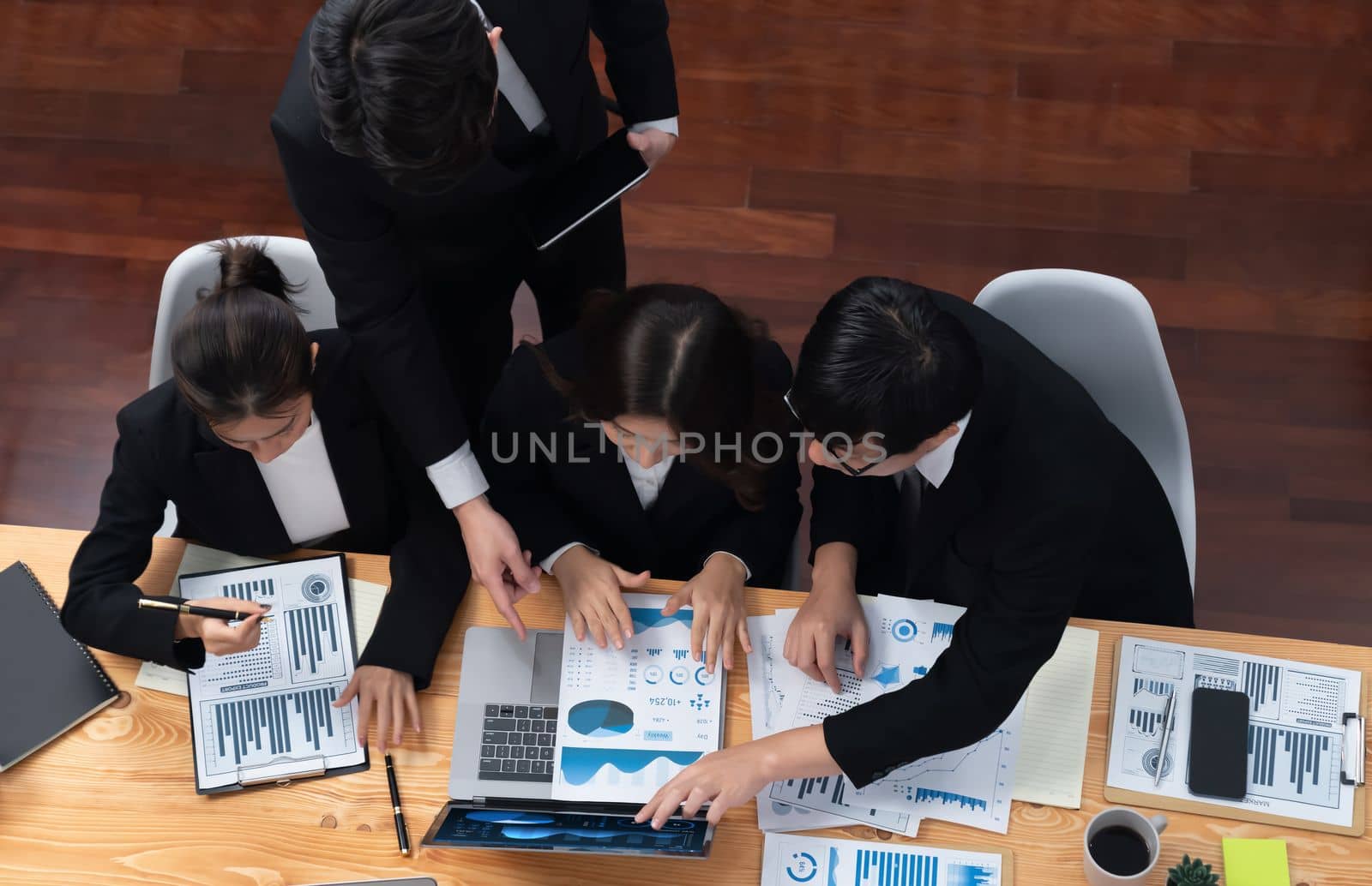 Top-view business team of financial data analysis meeting with business intelligence, report paper and dashboard on laptop for marketing strategy. Business people working together in office of harmony