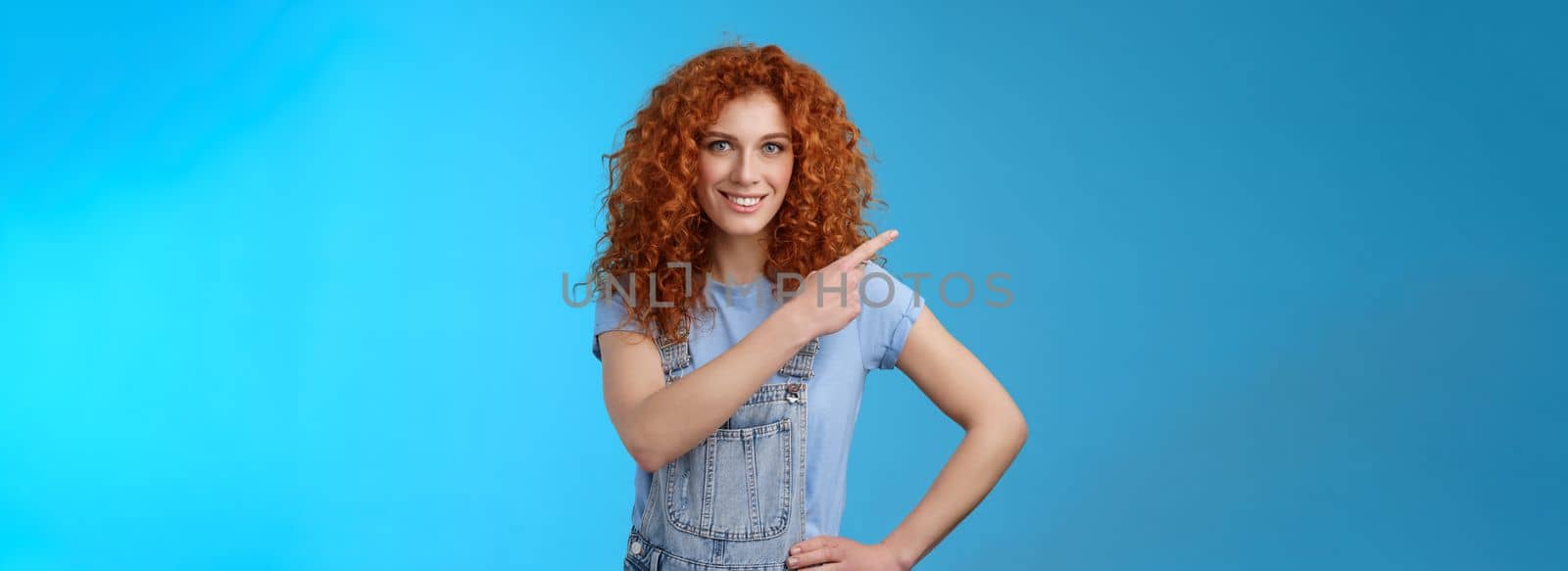 Girl suggest perfect place ad. Sassy good-looking empowered redhead daring woman smiling assertive motivated pointing upper left corner grin toothy confident you like promo blue background by Benzoix