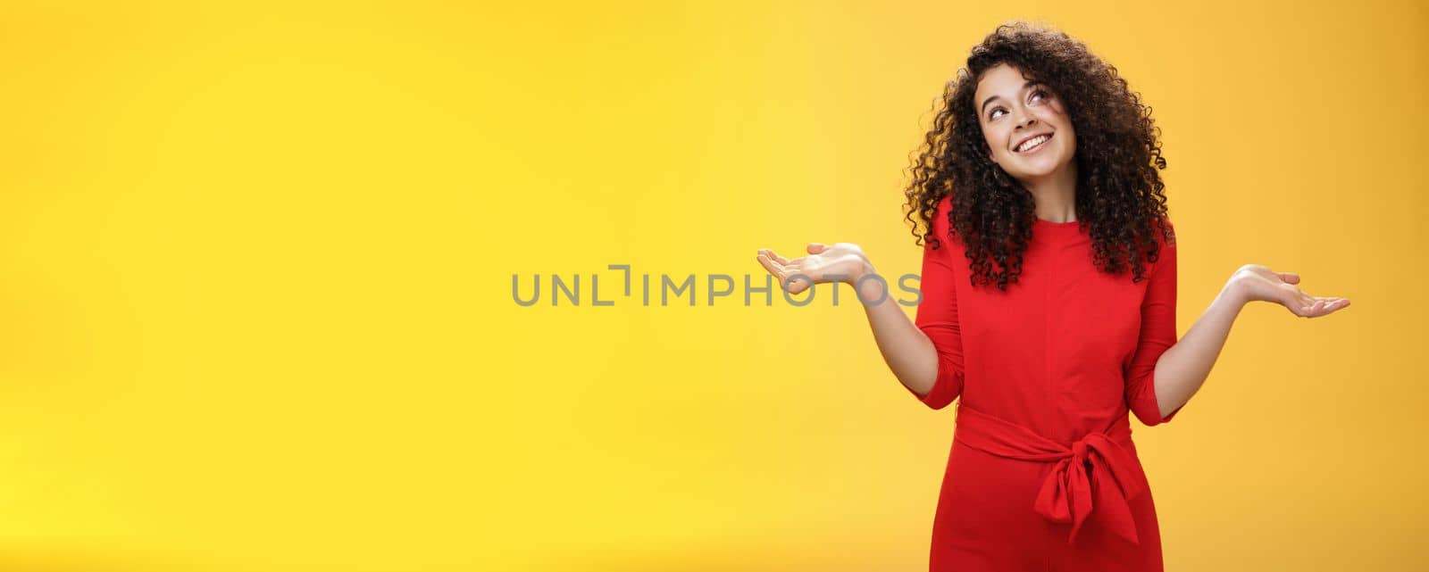 Girl feeling clueless and silly, being unbothered with anything, shrugging dreamy and indifferent, smiling carefree as looking dreamy at upper right corner, spread hands sideways in uncertain gesture.