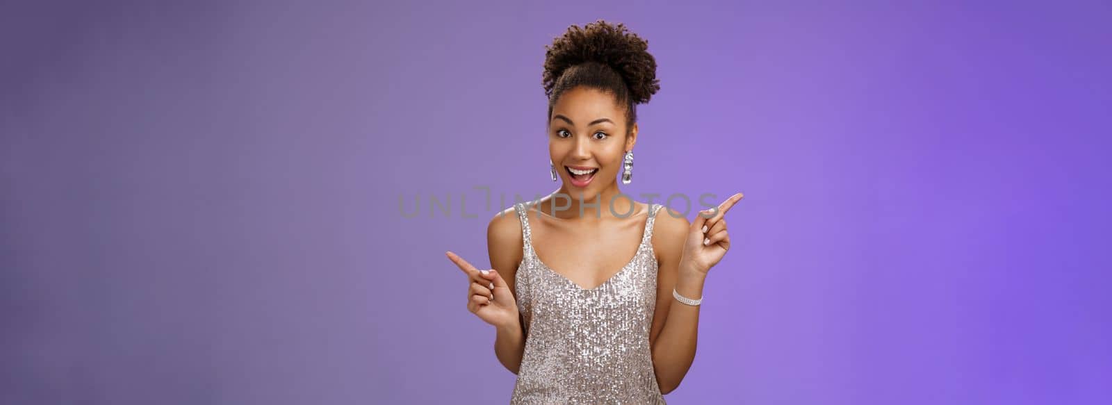 Charming outgoing african-american party girl have fun dancing pointing different sides right left show choices variants smiling broadly asking advice which way go, standing blue background.