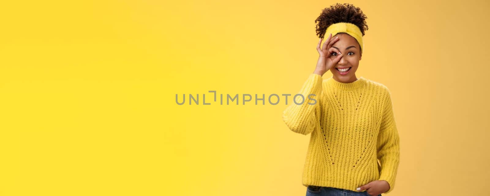 Charming tender feminine african-american girlfriend show circle on eye ok okay gesture look lucky happily smiling satisfied impressed waiting excitement travel friends, yellow background.