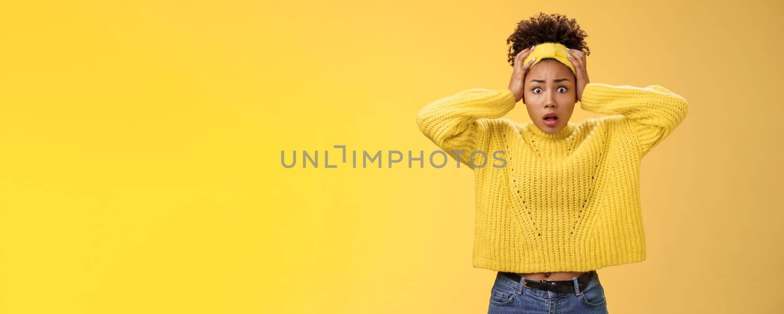 Troubled concerned perplexed female african-american employee duty look complicated panic hold hands head widen eyes shocked face troubles nervously thinking look anxious camera, yellow background.