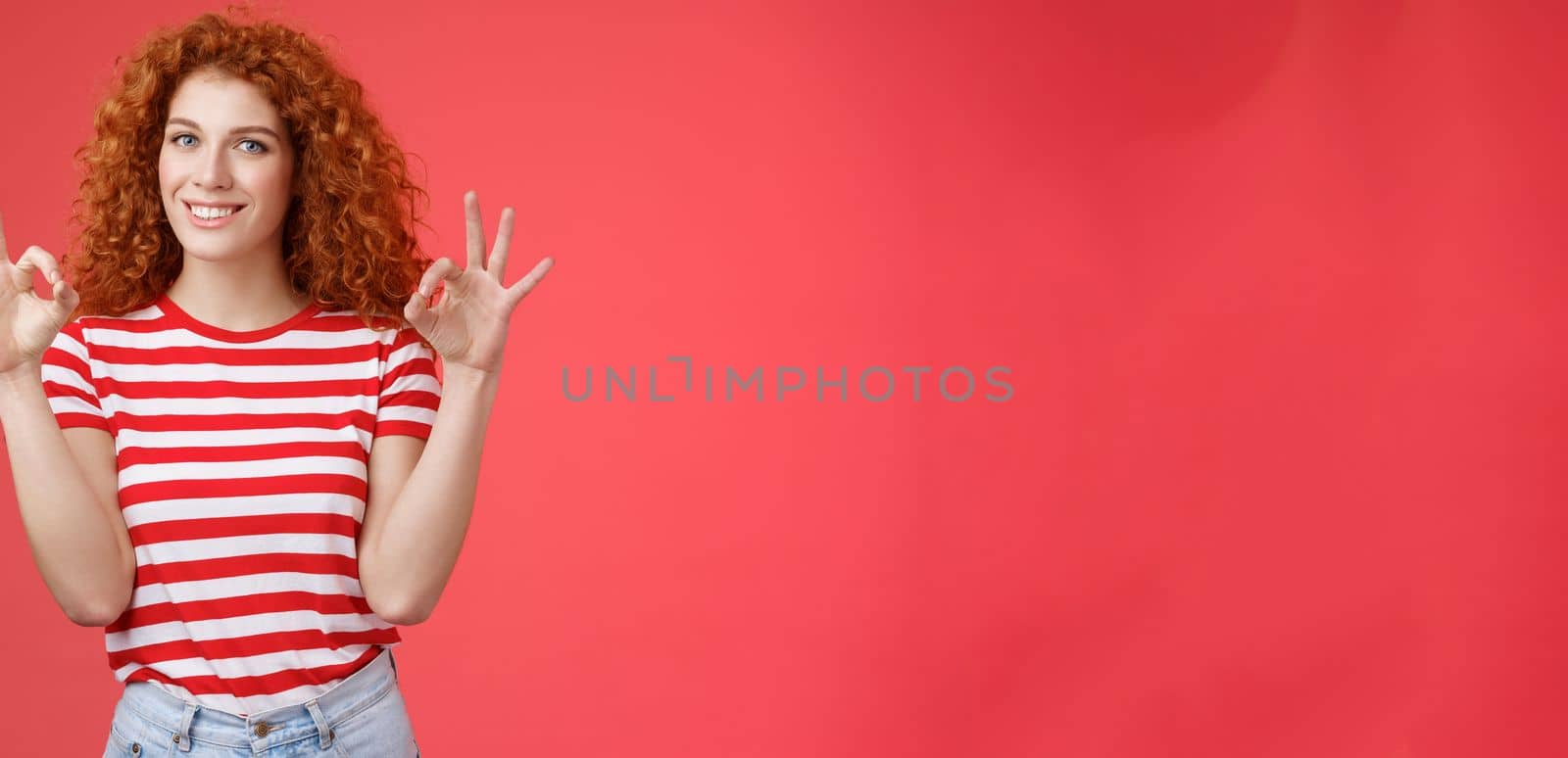 Fine relax everything perfect. Satisfied good-looking redhead cheerful sassy girlfriend curly haristyle show okay ok confirm gesture smiling approval agree good terms stand red background by Benzoix