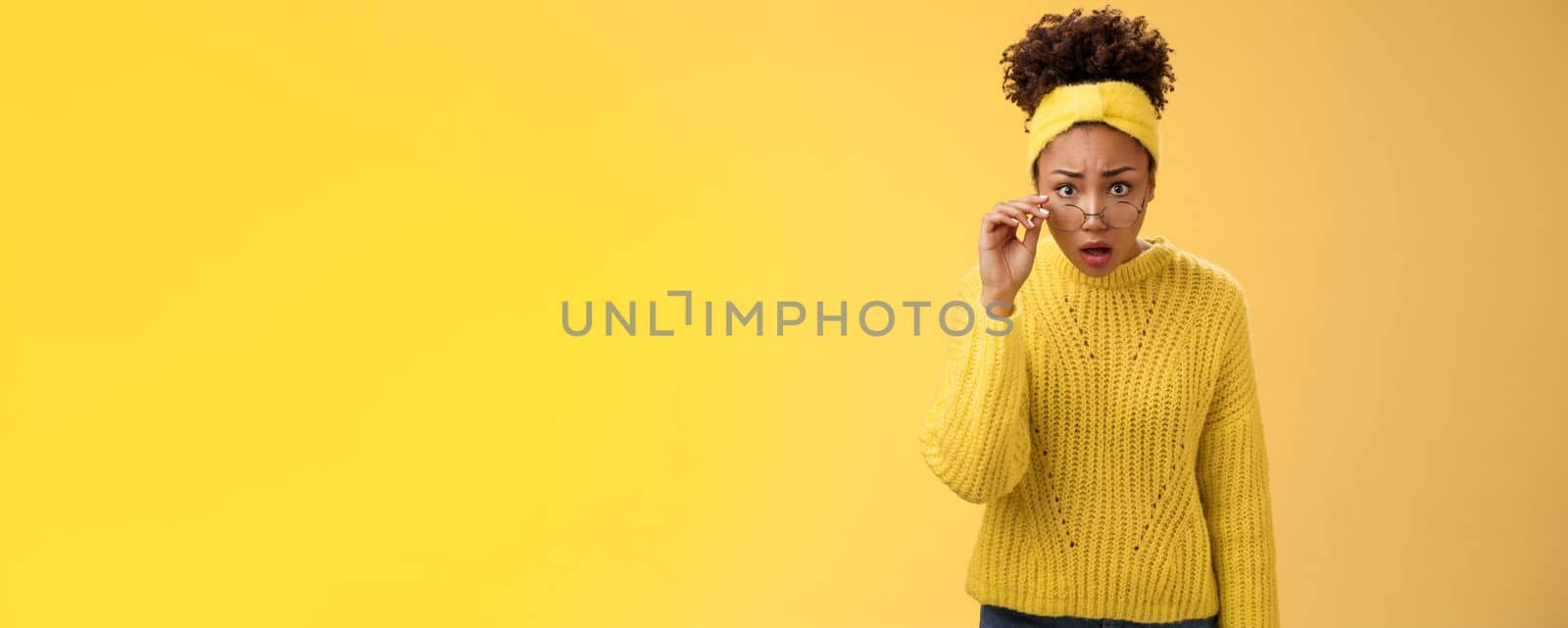 Shocked amazed african-american female student drop jaw gasping concerned confused take-off glasses bending forward reassure see truth, standing impressed speechless, yellow background by Benzoix