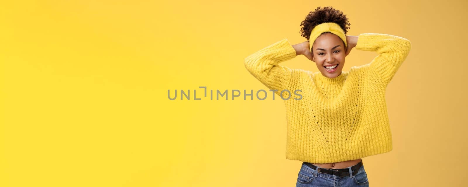Attractive lucky optimistic african-american woman having fun lay back hands behind head smiling laughing happily enjoying perfect day-off work relaxing spend leisure fun, yellow background.