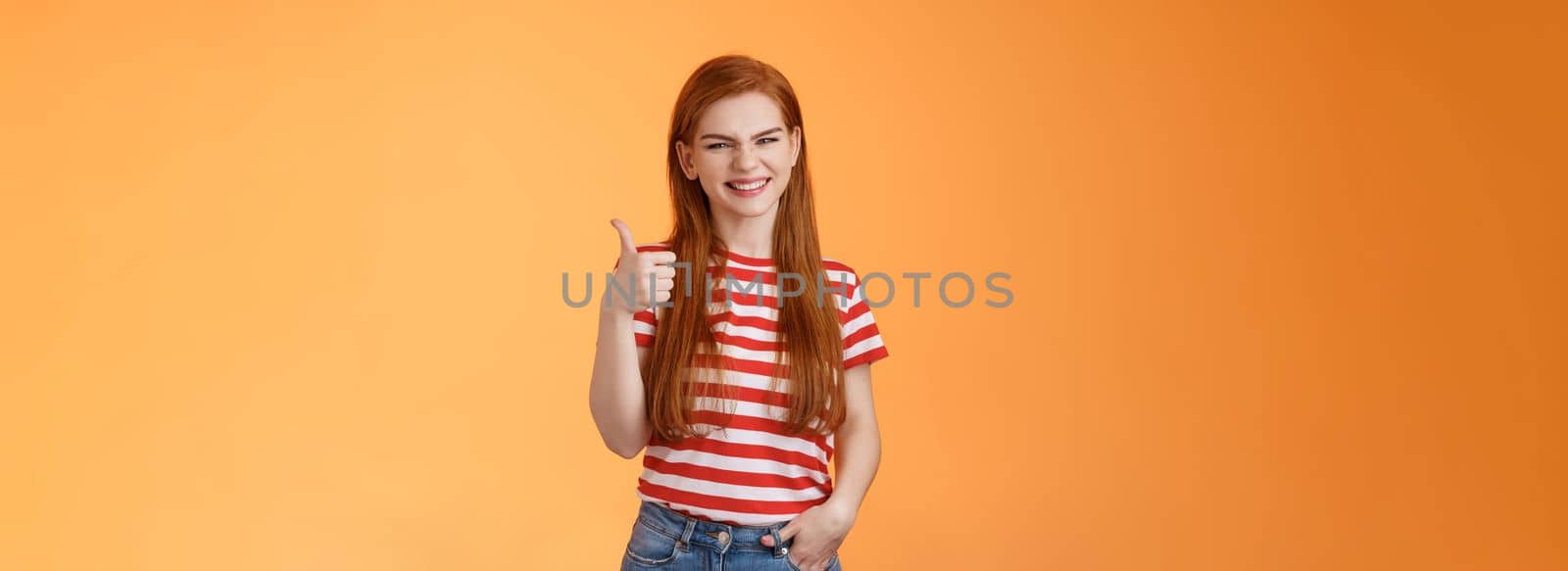 Cheerful friendly woman red natural hair clean skin, show thumb up, smiling approval, support perfect choice, like excellent performance, express positive opinion, acceptance, orange background by Benzoix