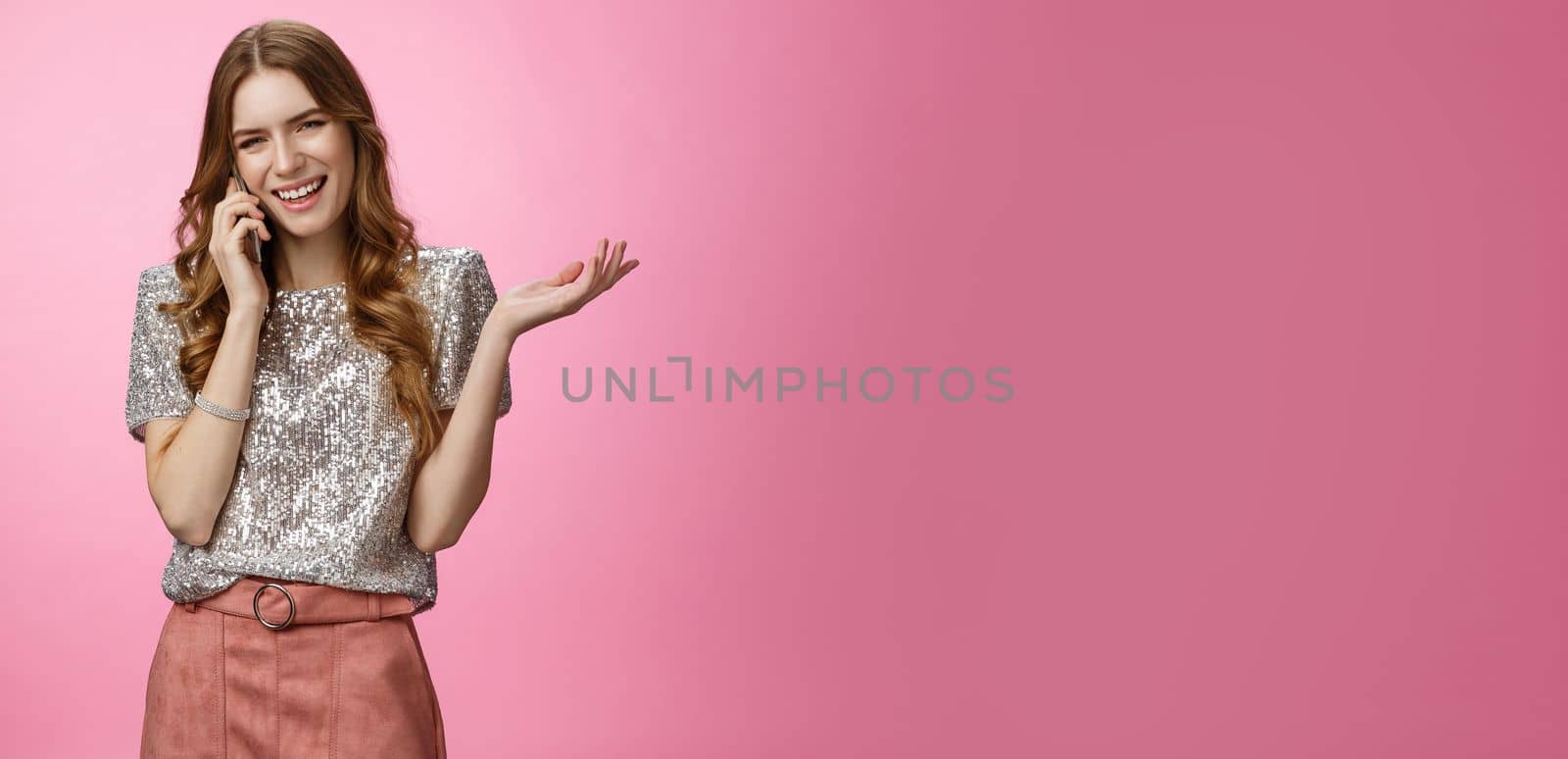 Sociable friendly-looking smiling happy glamour rich girl talking smartphone calling friend pleasant funny conversation laughing out loud joking gesturing talk mobile phone, pink background.