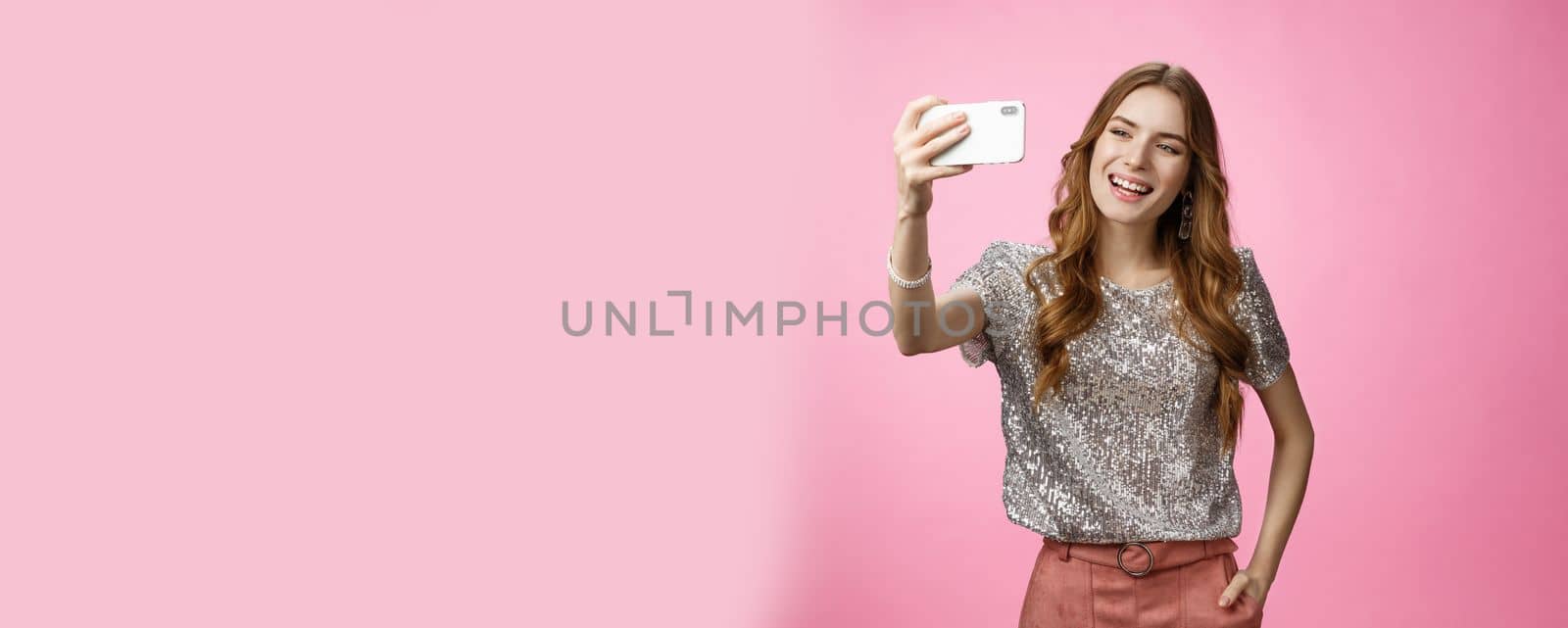 Sociable good-looking confident feminine caucasian woman recording video message taking selfie holding smartphone upper angle capturing image partying send photo online, posing pink background by Benzoix