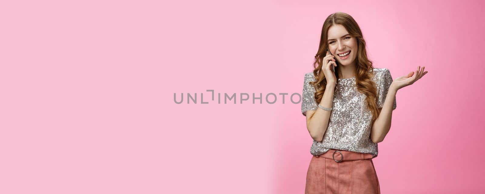 Sociable friendly-looking smiling happy glamour rich girl talking smartphone calling friend pleasant funny conversation laughing out loud joking gesturing talk mobile phone, pink background.