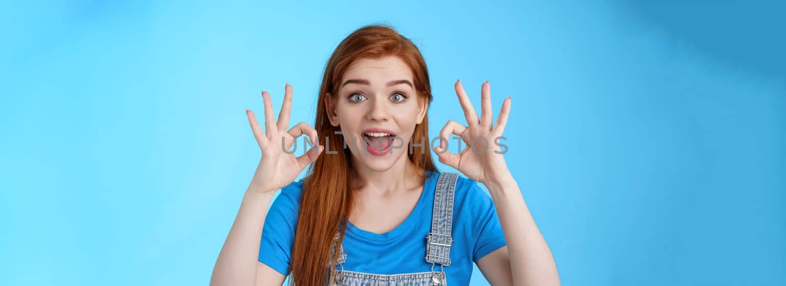 Excellent choice. Redhead female friend approve awesome idea, support accept good purshace, show okay ok confirmation gesture, smiling judging, give positive feedback, stand satisfied blue background.