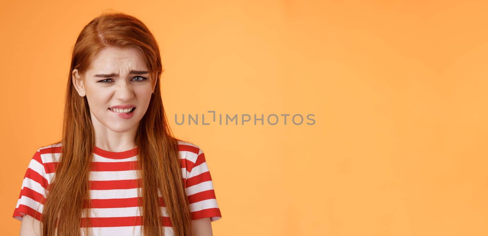 Cute disgusted redhead girl cringe from aversion bad awful smell, frowning grimace disappointed, clench teeth bothered, express dislike and reluctance, feel bad dissatisfied, refuse offer by Benzoix