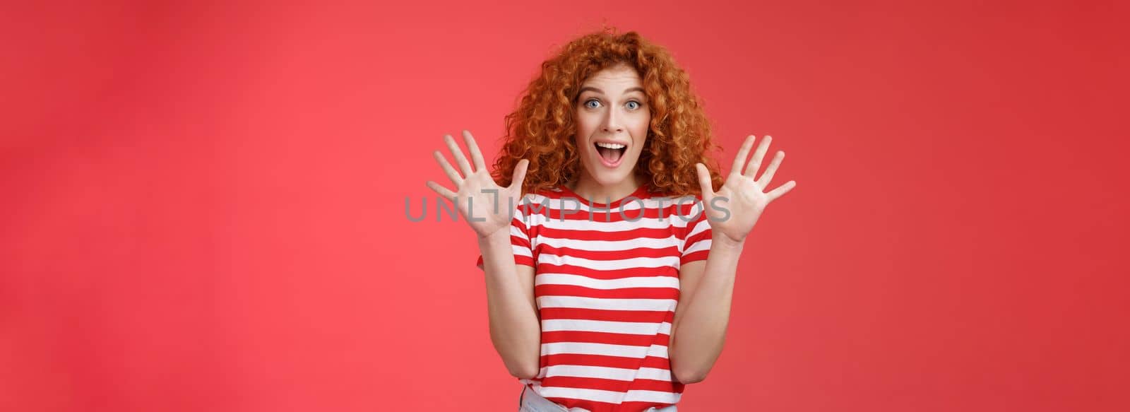 Extremely wonderful news she excited. Thrilled emotive gorgeous redhead woman scream amazed awesome surprise raise hands waving impressed open mouth stare charmed fascinated red background.