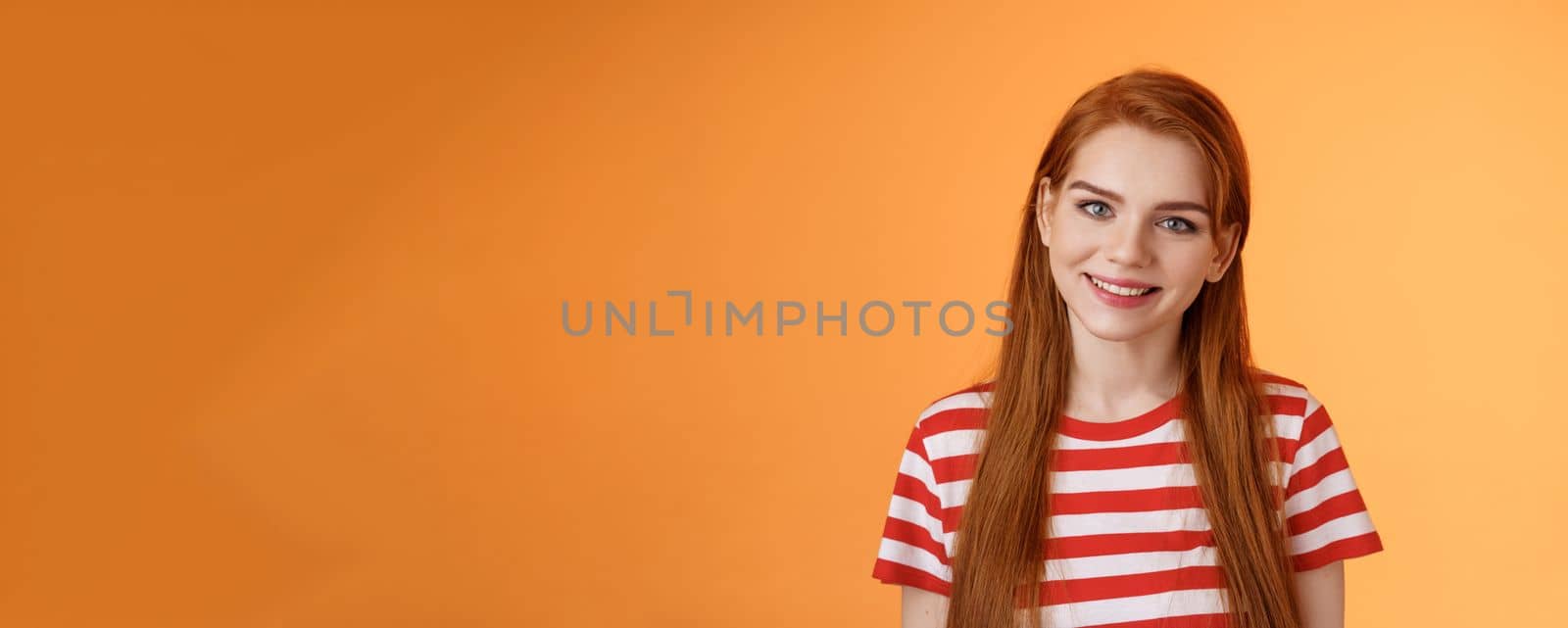 Close-up tender cute redhead young woman smiling joyfully, express happiness friendly emotions, look camera silly lovely grin, gaze satisfied, chat delighted, pleasant conversation orange background.