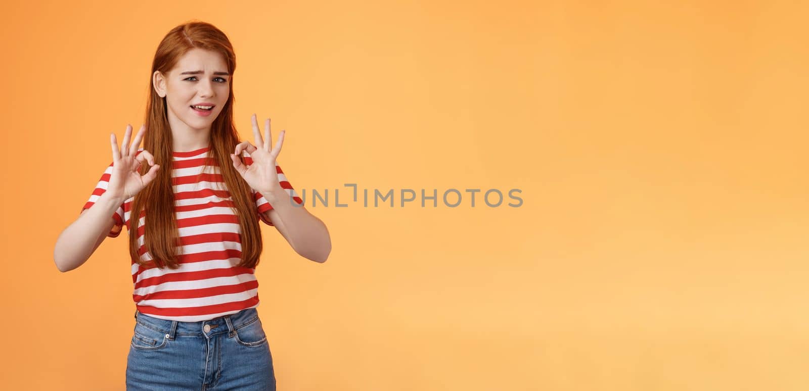 Chill carefree relaxed redhead girl assure everything fine, make okay signs, approval, nothing worry about everything good, stand orange background unbothered, satisfied not bad result.