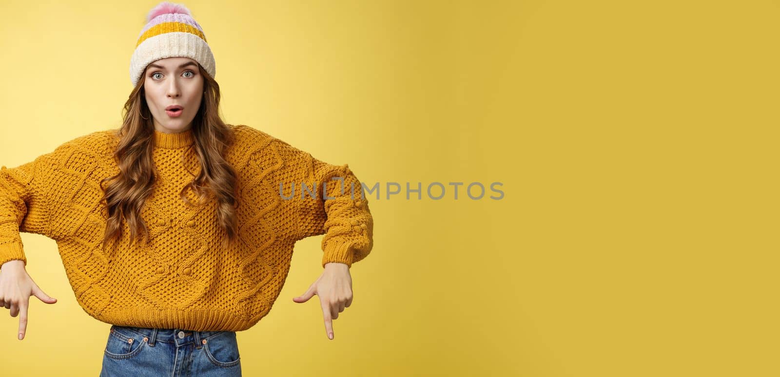 Wow stunning promo. Amused surprised good-looking stylish glamour young woman promoting interesting copy space folding lips amazed widen eyes pointing index fingers down bottom advertisement.
