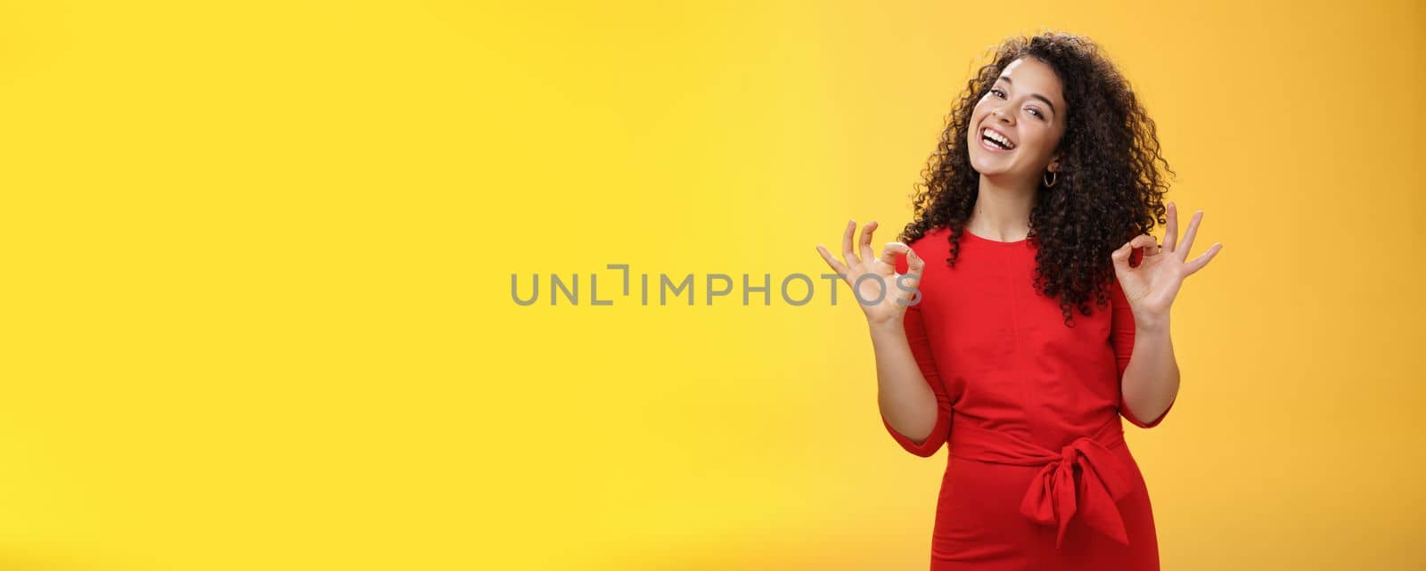 Lifestyle. Charming girl living dream standing happy and satisfied as liking new apartment rent with boyfriend showing okay gesture and tilting head with broad smile approving cool place over yellow background.