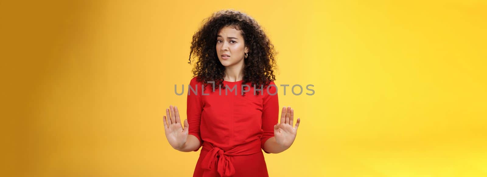 Lifestyle. Girl unwiling got in troubles rejecting suspicious and doubtful offer pulling raised palms in no and refusal gesture turning head with grimace from aversion and disgust looking with contempt at camera.