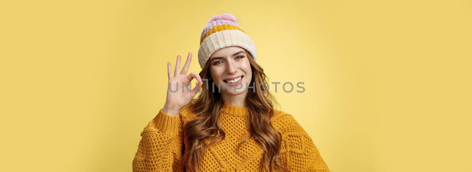 Everything under control. Self-assured optimstic lucky cute girl show okay ok gesture smiling happily having things alright, fine recommend awesome product, pleased standing yellow background by Benzoix