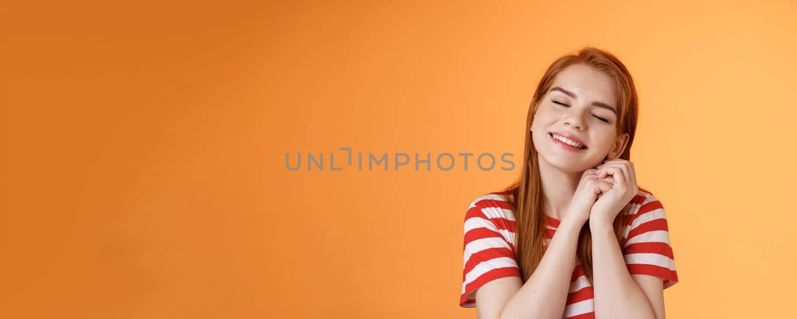 Silly dreamy redhead girl, look hopeful, press palms together lovely near cheek close eyes, daydreaming imaging dad buys new smartphone after graduation, fantasizing, remember good memories by Benzoix