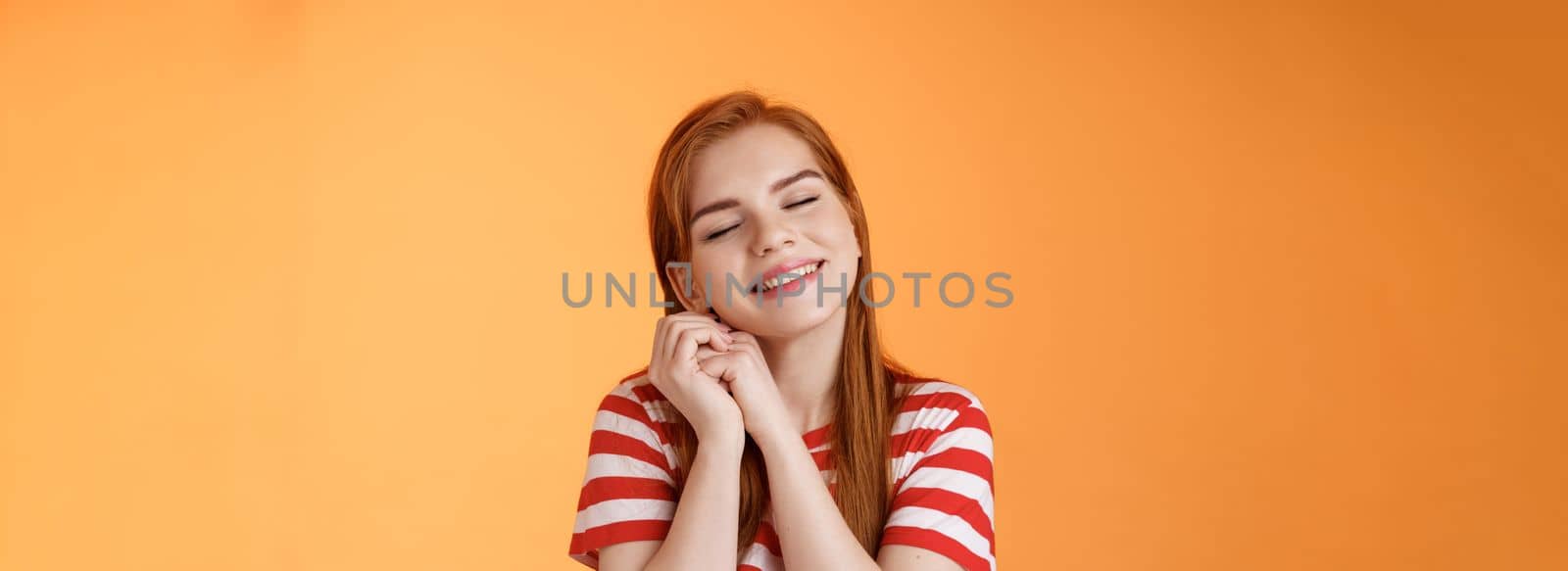 Silly dreamy redhead girl, look hopeful, press palms together lovely near cheek close eyes, daydreaming imaging dad buys new smartphone after graduation, fantasizing, remember good memories.
