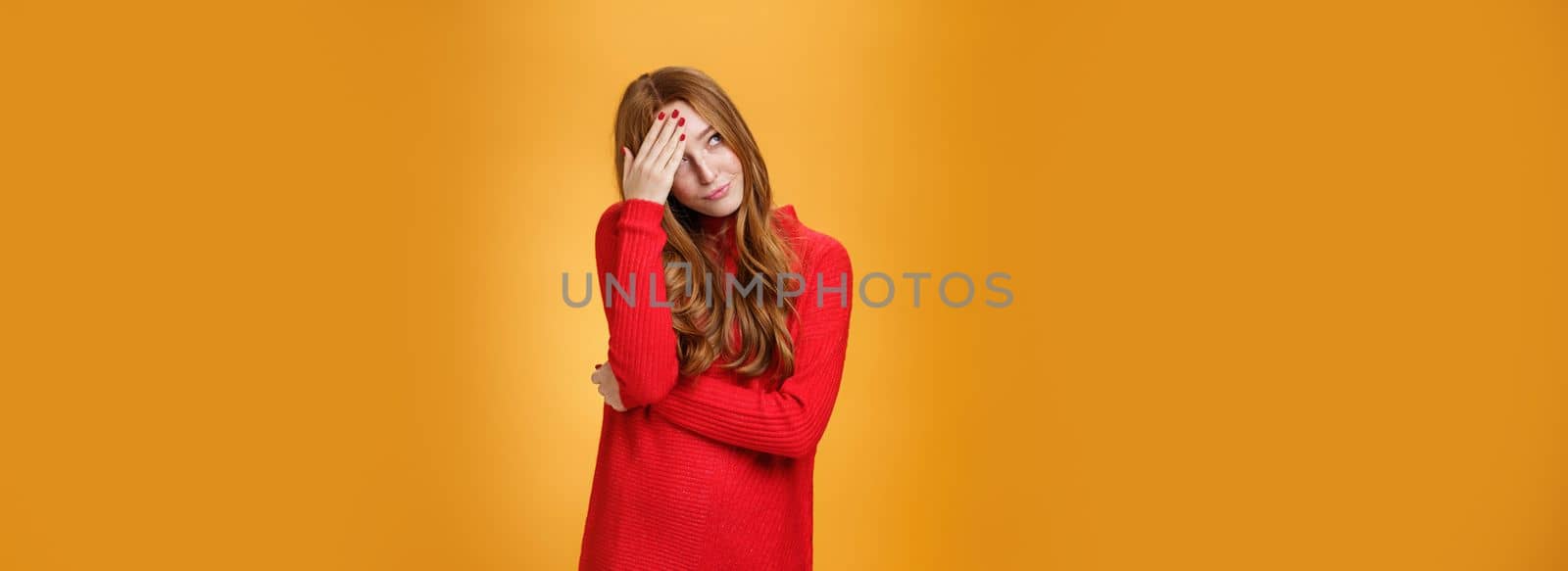 Annoyed and pissed embarrassed woman hiding behind hand making facepalm gesture looking away with irritated humiliated gesture, standing fed up and intense against orange background by Benzoix