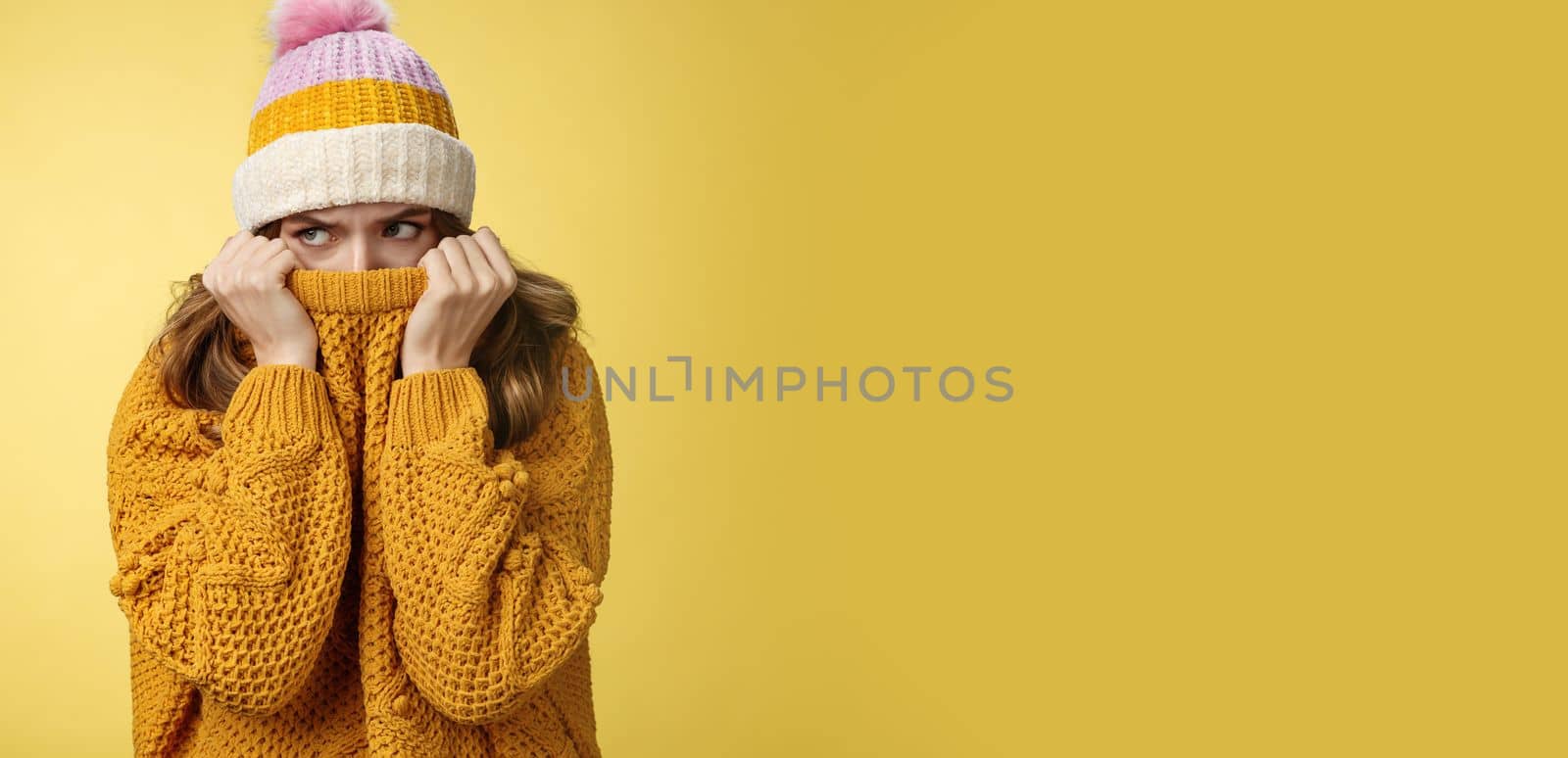 Offended sad whining cute tender young girl hiding face pull sweater nose peek look aside insulted complaining being insulted, standing miserable upset wearing warm winter corduroy hat.