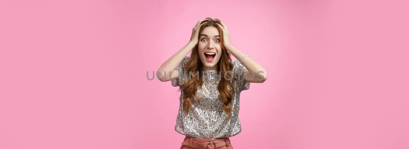 Excited happy surprised charming glamour young girl winning unexpectedly grab head amazed drop jaw smiling look camera astonished thrilled happiness, standing astonished pink background.
