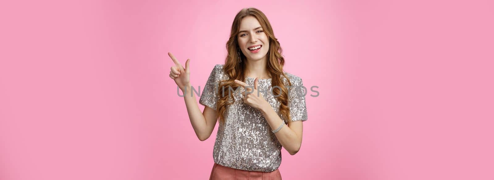 Positive friendly-looking glamour stylish young woman inviting girlfriend check out new appartment throw party smiling broadly pointing upper right corner grinning happily enjoying awesome evening by Benzoix