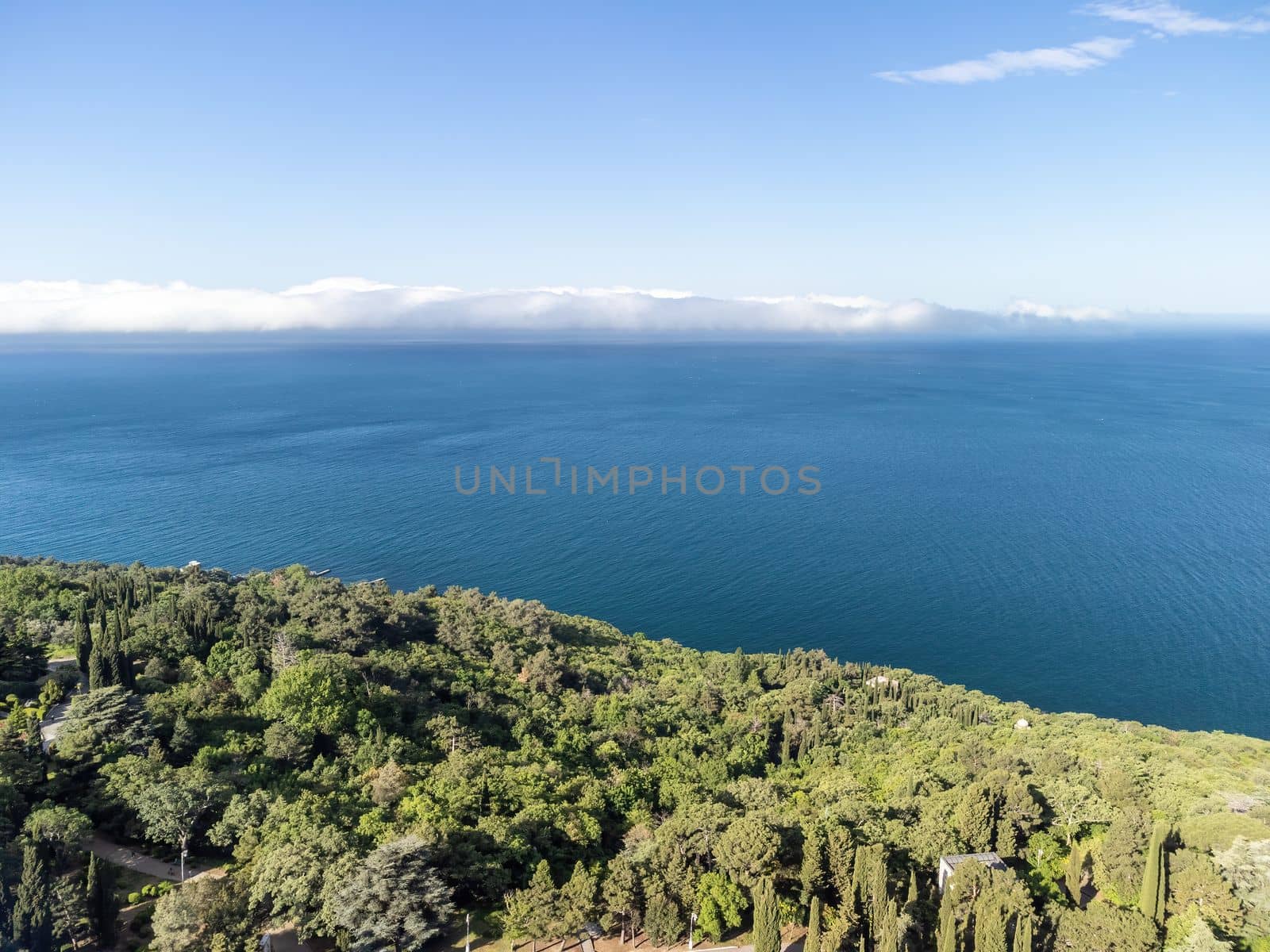 Sea landscape with rocky coastline on sunset time with cloudy sky. Yachts in the Sea on a background of rocky shores. The concept of perfect place for summer travel and rest.