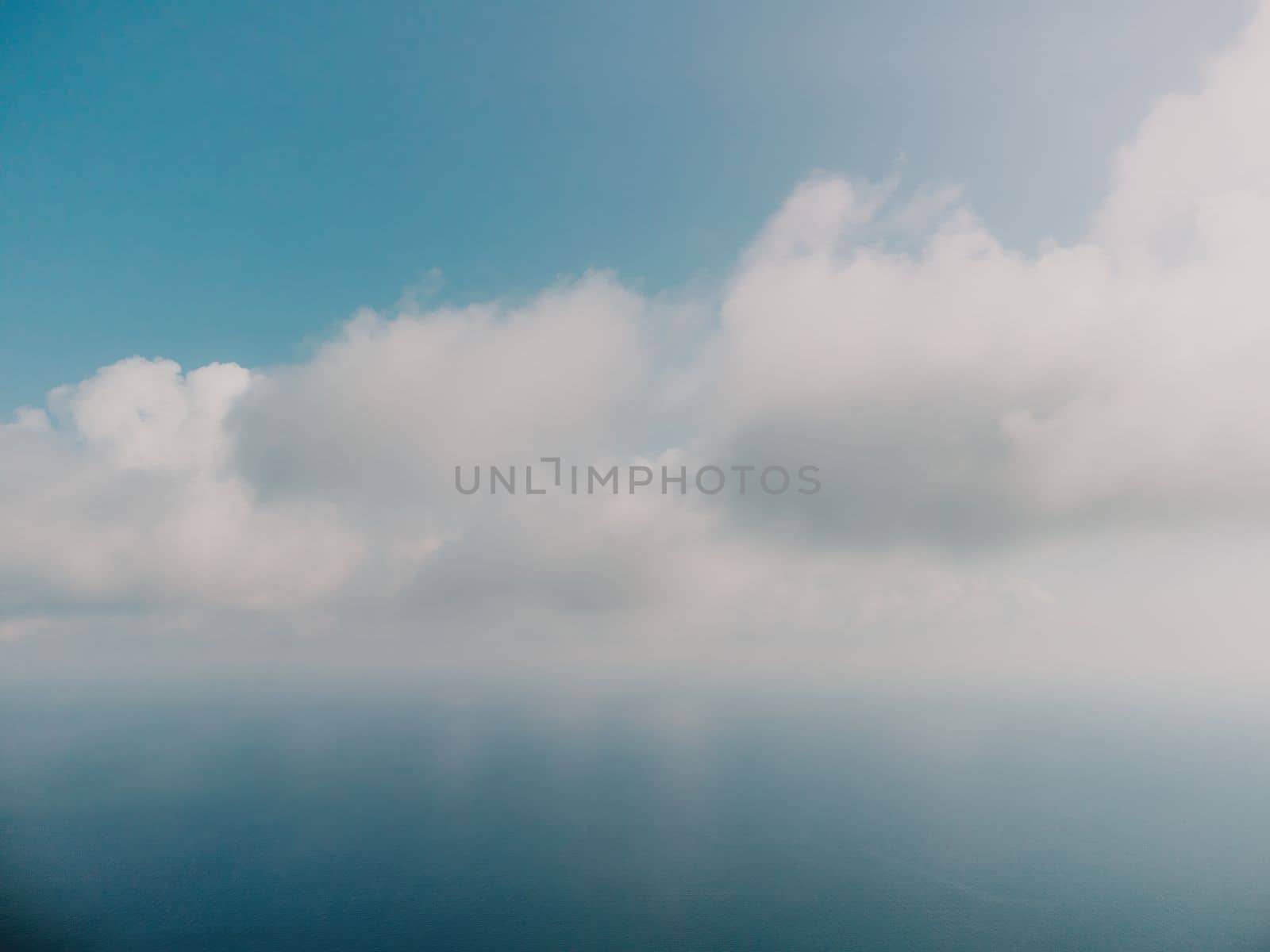 Blue sky with white clouds over calm summer panorama of the sea. Drone aerial view. Abstract aerial nature summer ocean sunset sea and sky background. Horizon. No people. Holiday and vacation concept by panophotograph