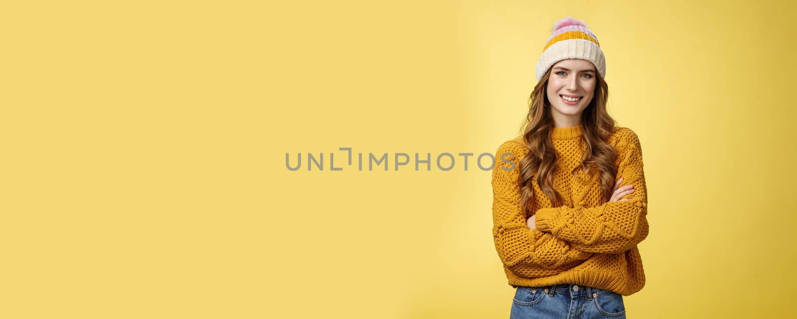 Lifestyle. Confident relaxed attractive outgoing caucasian 20s woman wearing hat stylish sweater cross arms chest smiling self-assured professional stylist ready help dress-up standing yellow background.