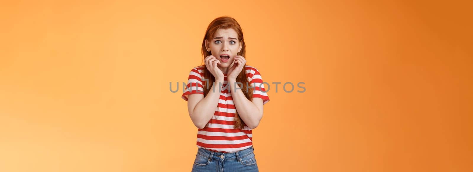 Innocent scared redhead female victim feel afraid standing stupor trembling fear, drop jaw gasping shocked, stare terrified, speechless look camera, frightened stand orange background by Benzoix