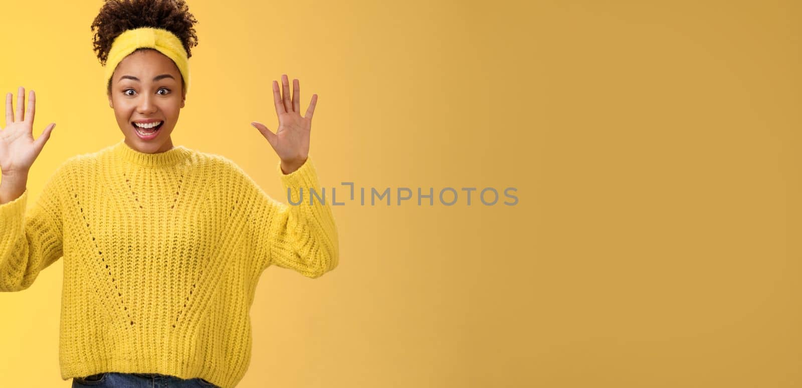 Charming excited smiling friendly millennial african-american girl raise hands nothing hide show palms high surrender standing amused thrilled grinning having fun posing yellow background by Benzoix