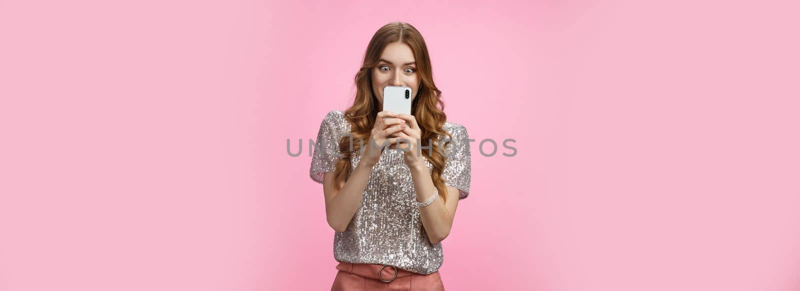 Amused curious good-looking stylish european glamour woman shopping online looking excited amazed smartphone screen find awesome sale promotion, standing thrilled texting hot fresh rumor friend.