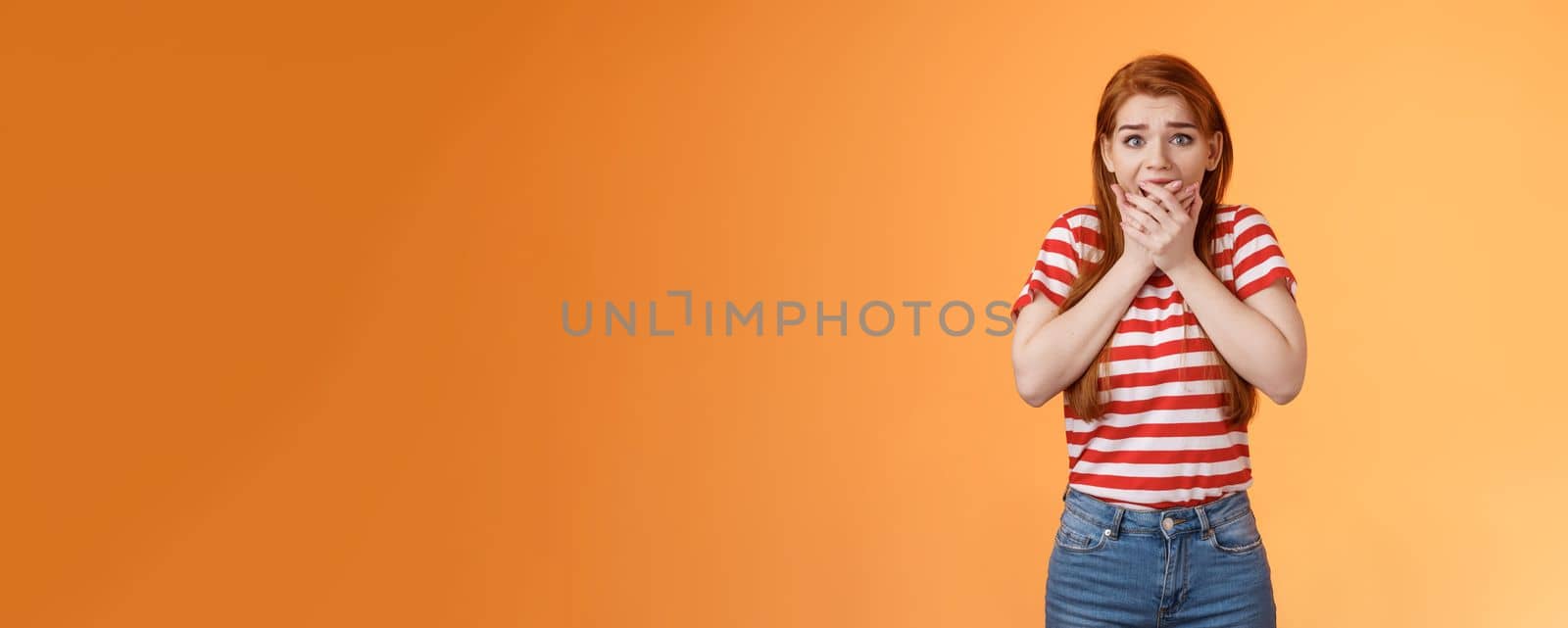 Scared speechless innocent female victim losing speech, press hands mouth shocked terrified stare camera frightened, trembling from fear, see someone commiting crime, insecure orange background.