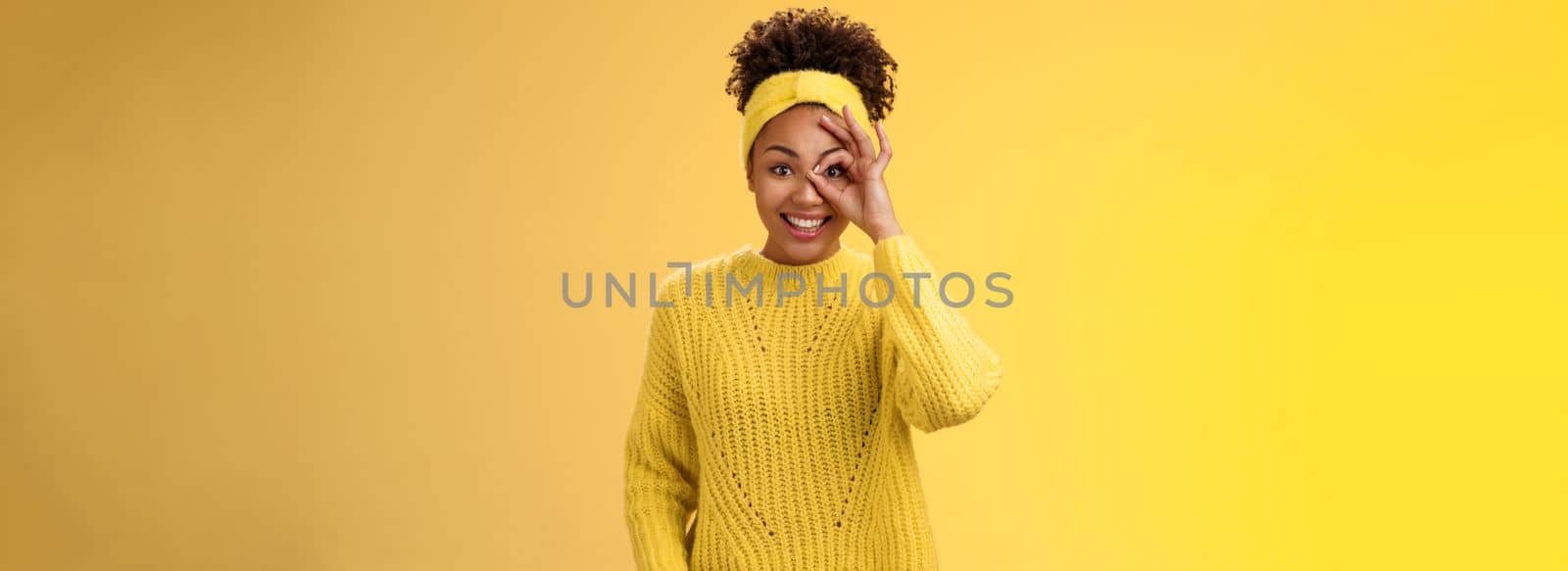 Charming tender feminine african-american girlfriend show circle on eye ok okay gesture look lucky happily smiling satisfied impressed waiting excitement travel friends, yellow background by Benzoix
