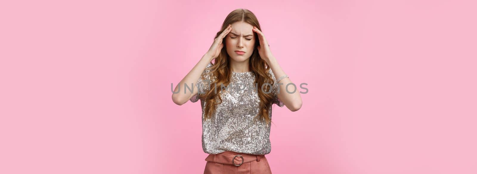 Caucasian woman feeling dizzy drink too much alcohol party, touching temples close eyes frowning suffering headache feeling discomfort, migraine, standing displeased unwell pink background.