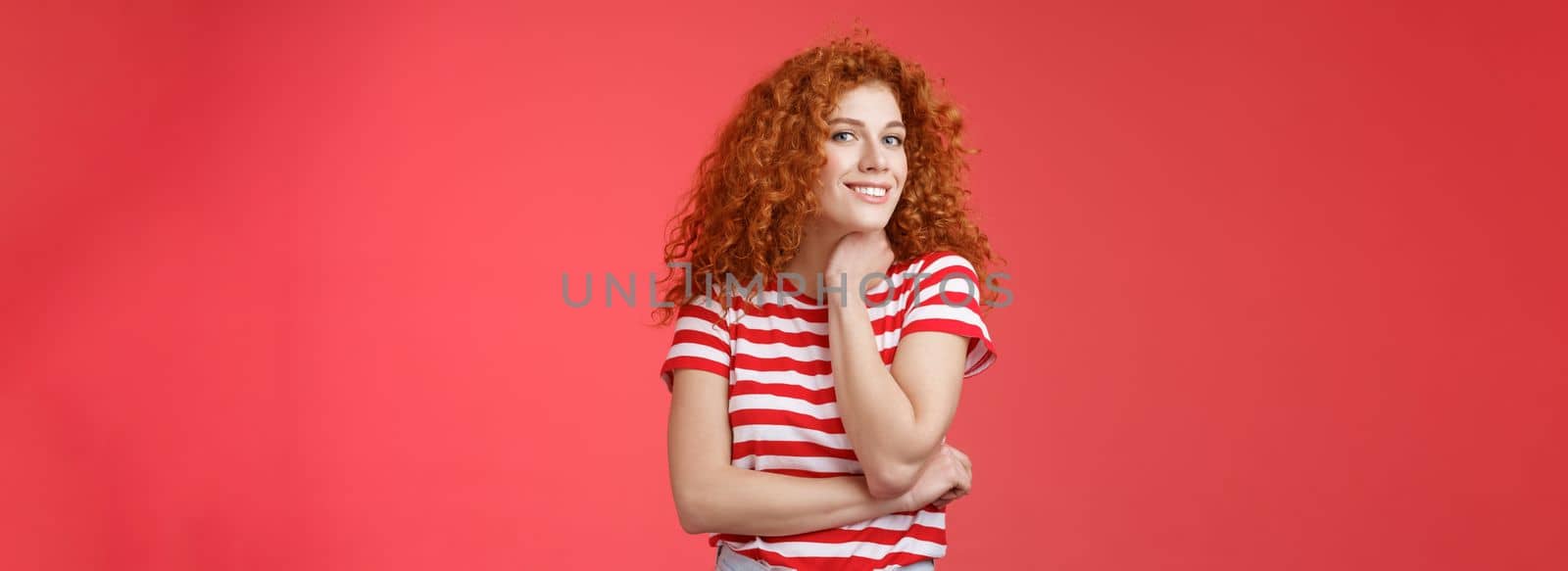 Cheerful lively cute tender redhead curly girl romantic summer mood pondering what present girlfriend happy pride month silly smiling touch face-line look curious camera red background by Benzoix