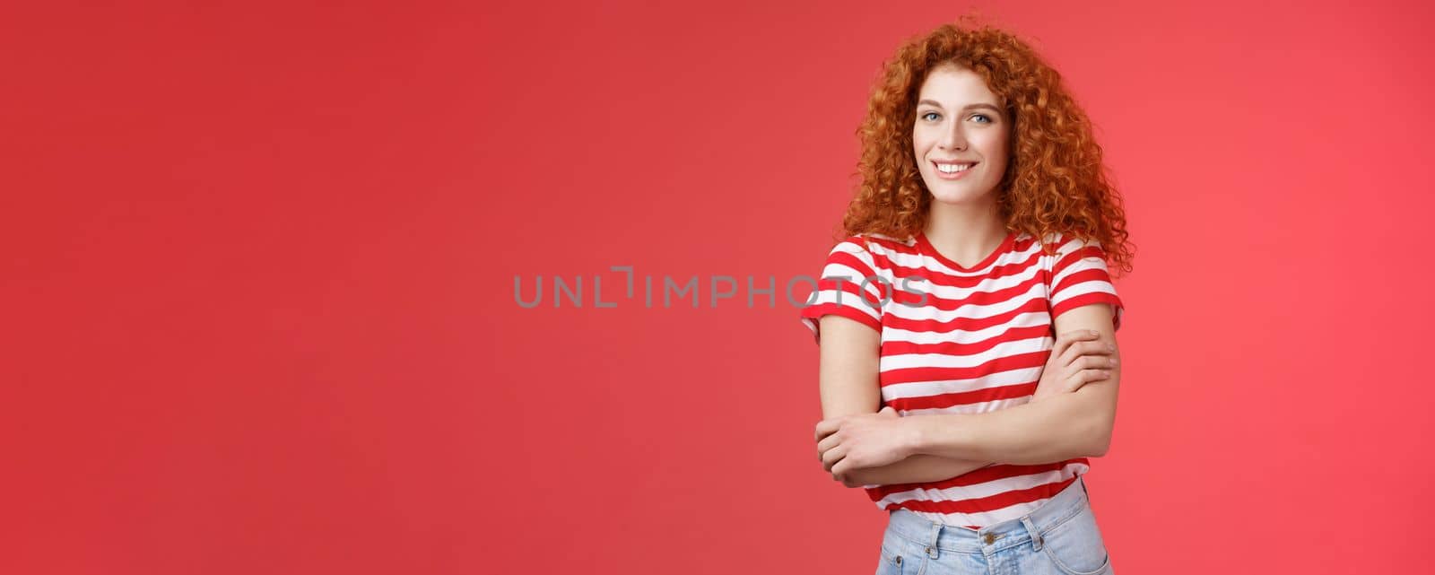 Lifestyle. Confident tender silly redhead beautiful curly-haired girl cross arms body smiling broadly delighted amused cheerfully enjoy warm summer evening walks tropical country holiday red background.