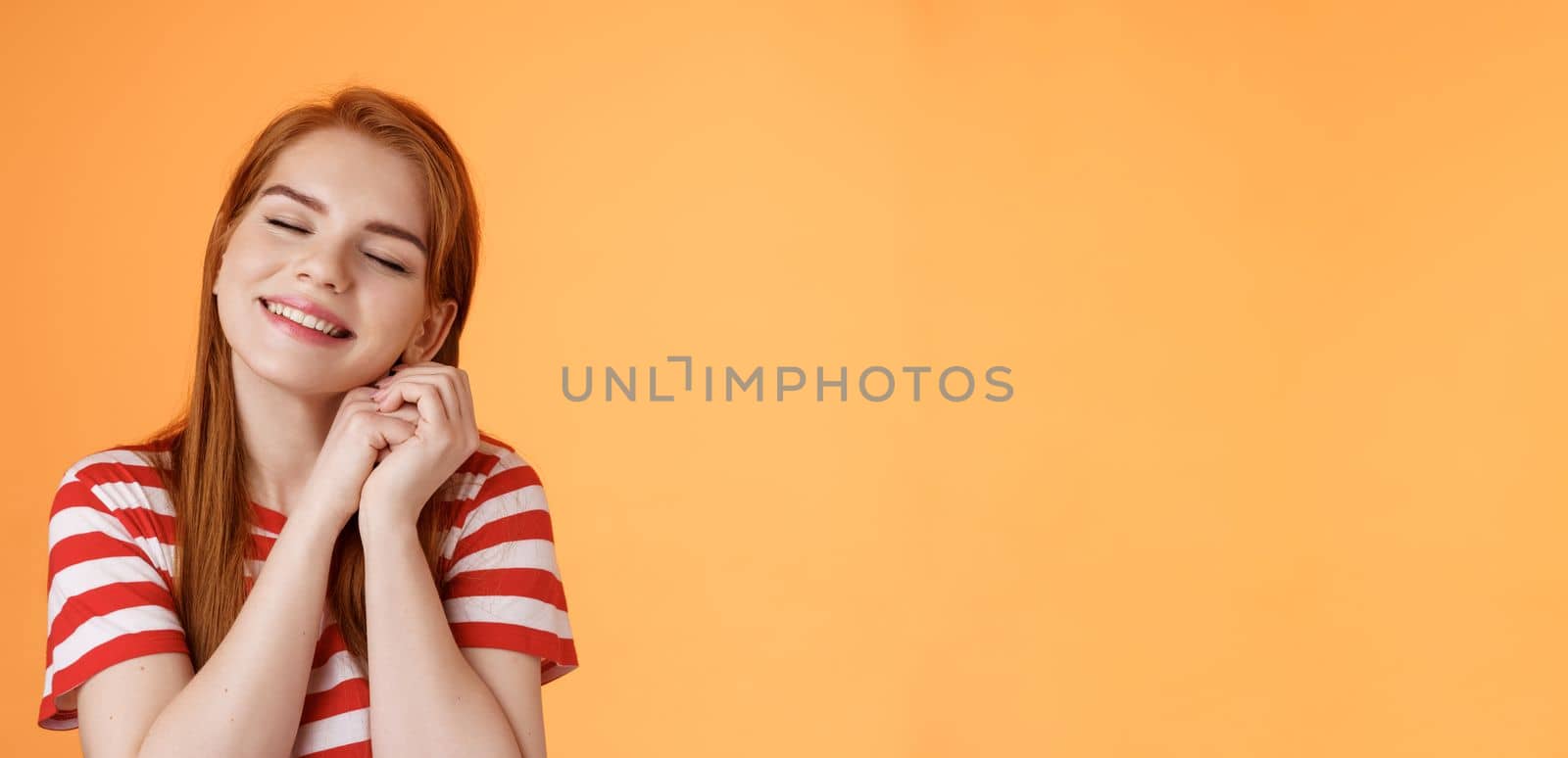 Silly dreamy redhead girl, look hopeful, press palms together lovely near cheek close eyes, daydreaming imaging dad buys new smartphone after graduation, fantasizing, remember good memories.