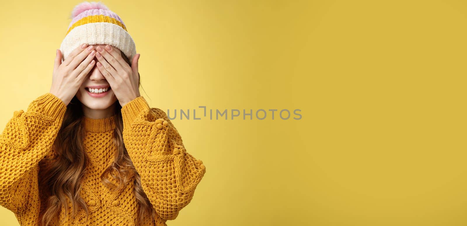 Close-up studio shot charming cute young girl waiting surprise press palms eyes smiling anticipating secret present, standing amused cannot wait gaze awesome gift, birthday party concept.