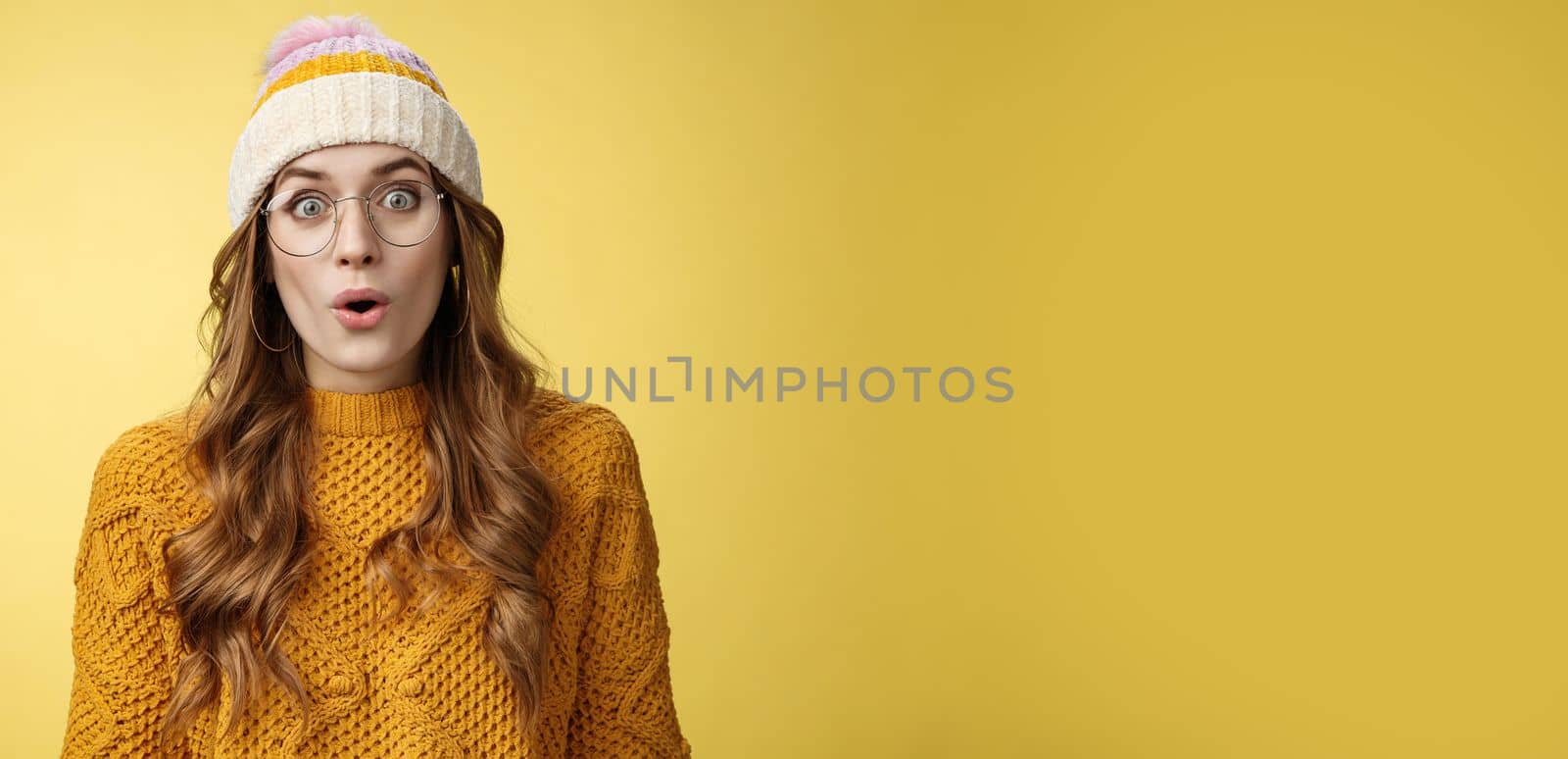 Surprised amazed charismatic good-looking young female student widen eyes wondered say wow amazed standing shocked impressed yellow background, wearing nerd glasses hat sweater by Benzoix