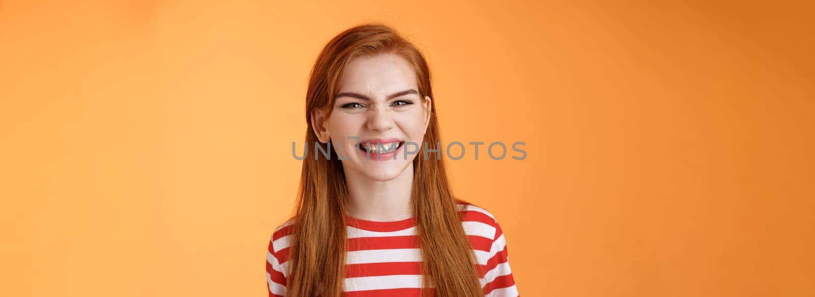 Close-up sassy good-looking cheerful redhead sly girl smiling toothy white perfect grin, satisfied dental clinic professional cleaning, standing orange background happy, joyful summer mood.