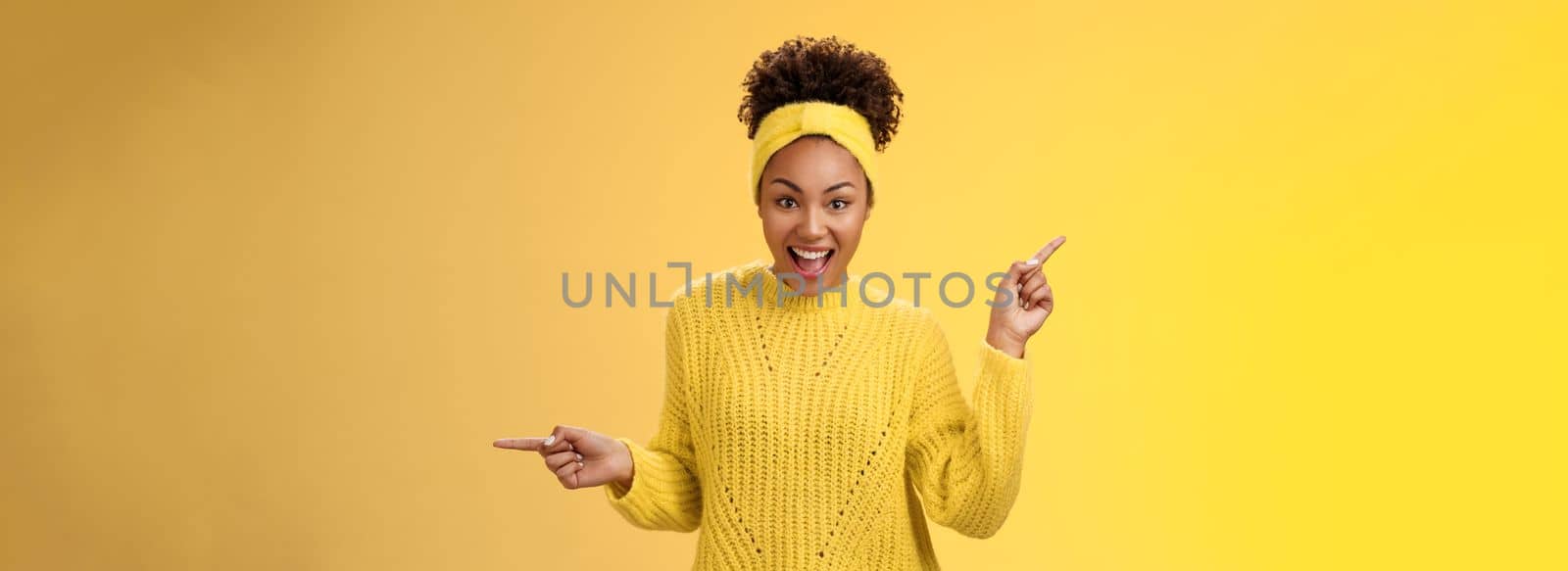 Energized active charismatic african-american woman afro hairstyle in sweater headband screaming fascinated enthusiastic pointing left right impressed variaty awesome choices, picking products.